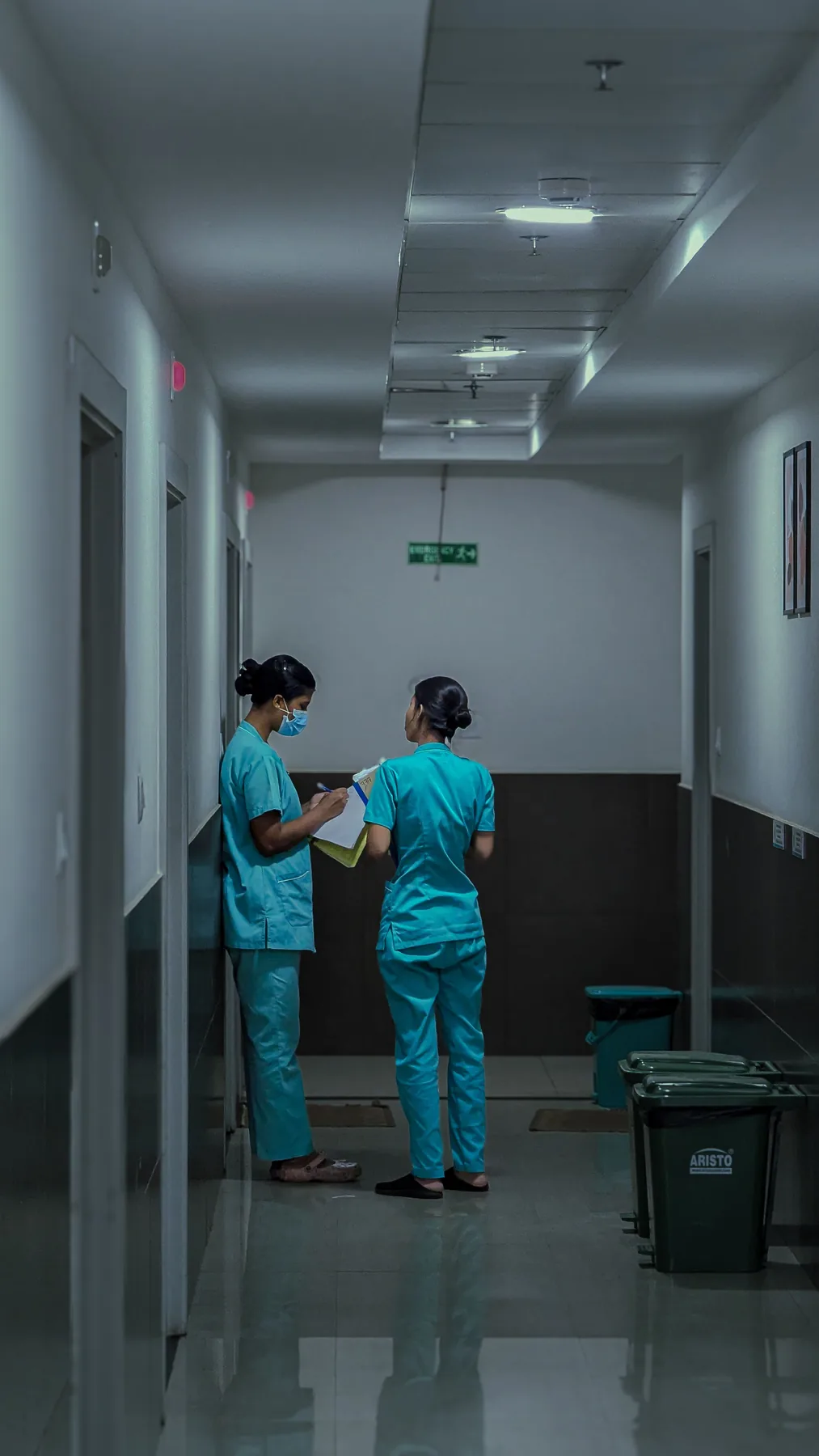 Healthcare professionals reviewing notes in an Indian hospital corridor